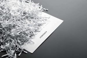 Big heap of white shredded papers on list with agreement